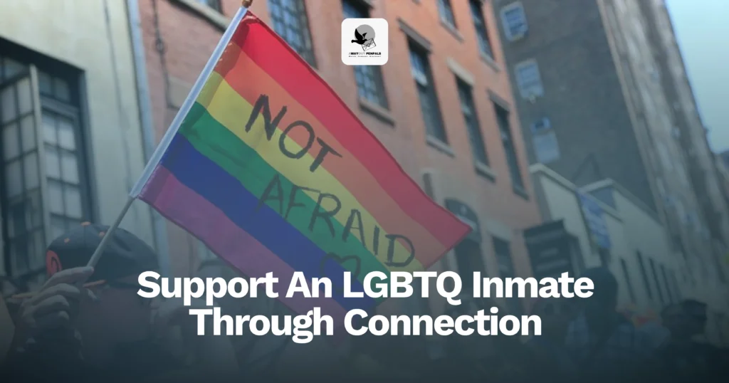 Person holding a rainbow flag that says "NOT AFRAID" on a city street; overlaid text reads, "Support An LGBTQ Inmate Through Connection.